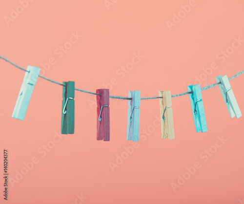 Flowers pinned on clothesline. Minimalism background. Blue, orange, gray background. High resolution photo.