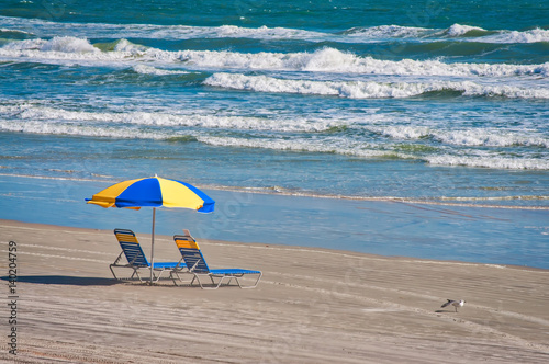 Two chairs on the beach under umbrella