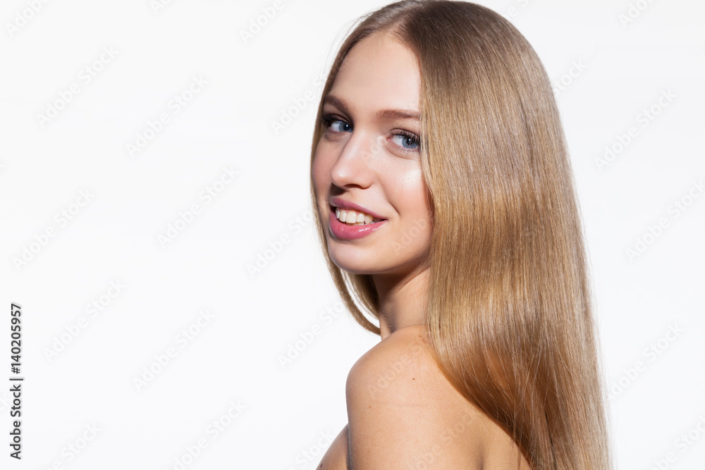 Smiling blonde model woman with long shiny hair looking at camera on white background