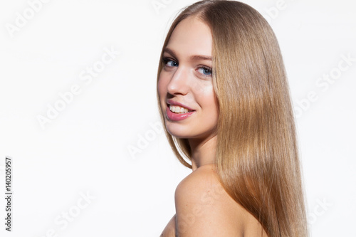 Smiling blonde model woman with long shiny hair looking at camera on white background