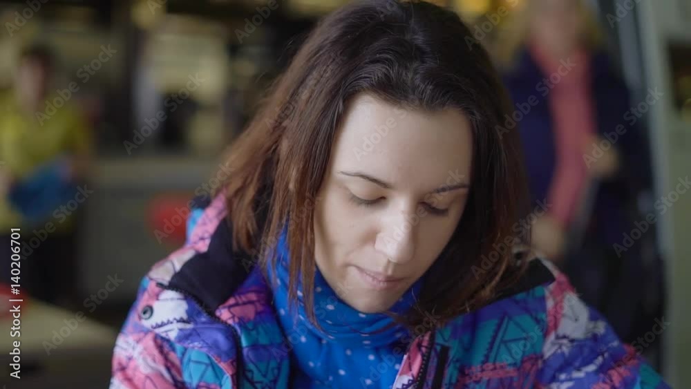 The girl ran into the cafe from the street, that would quickly eat. The brunette sits in a sports jacket and eats French fries in a fast food restaurant. The girl ran into the cafe from the street, that would quickly eat. The brunette sits in a sports jacket and eats French fries in a fast food restaurant.