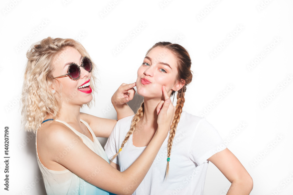 Woman pressuring on friend's cheeks Woman pressuring on friend's cheeks