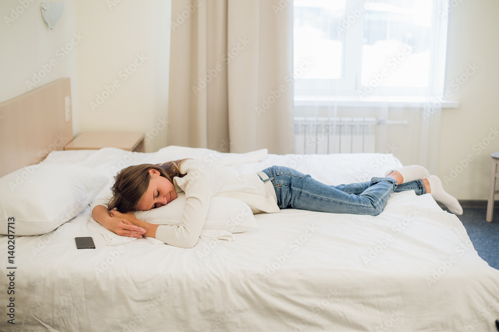 A woman laying on her bed still dressed in her clothes to tired to get in the bed. A woman laying on her bed still dressed in her clothes to tired to get in the bed.