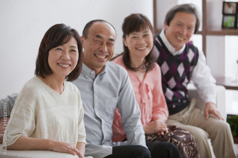 Couples sitting on sofa looking at Camera Couples sitting on sofa looking at Camera