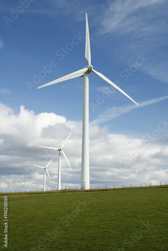 Three electricity generating windmills on a rural hillside