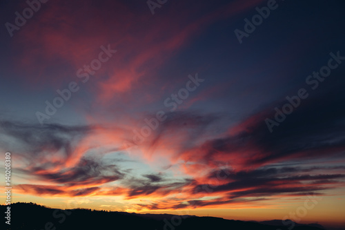 Beautiful red sunset over the field and forest