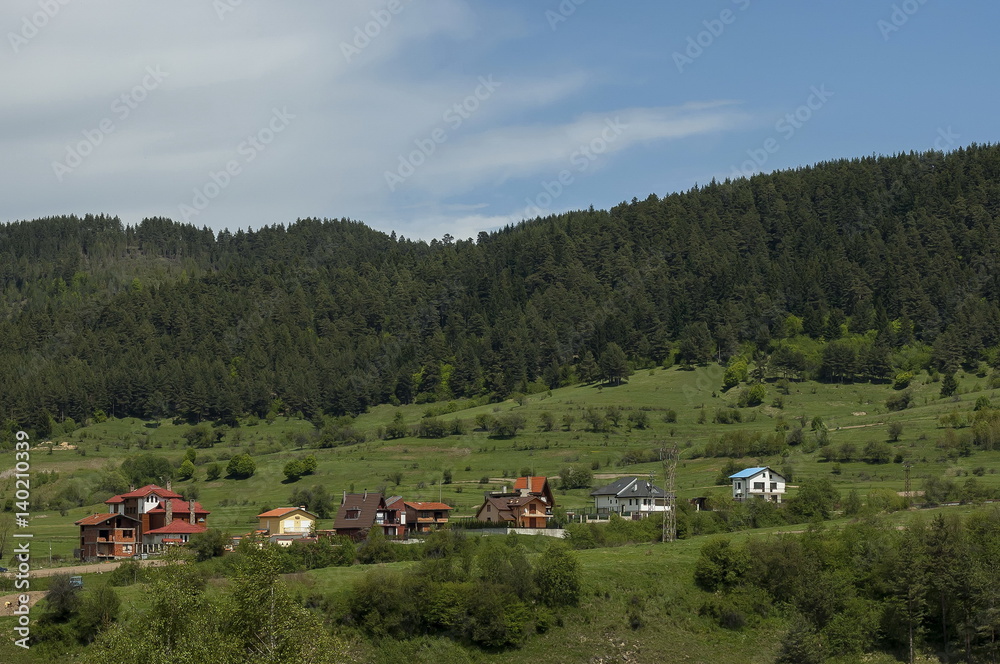 Scene with mountain top, valley and residential district of bulgarian village Beli Iskar, Rila mountain, Bulgaria