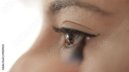Macro shot of woman apply eyeliner photo