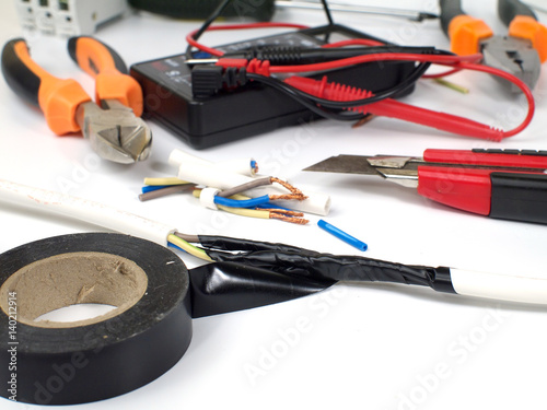 insulating electrical wire connection with black electric tape, shallow depth of field