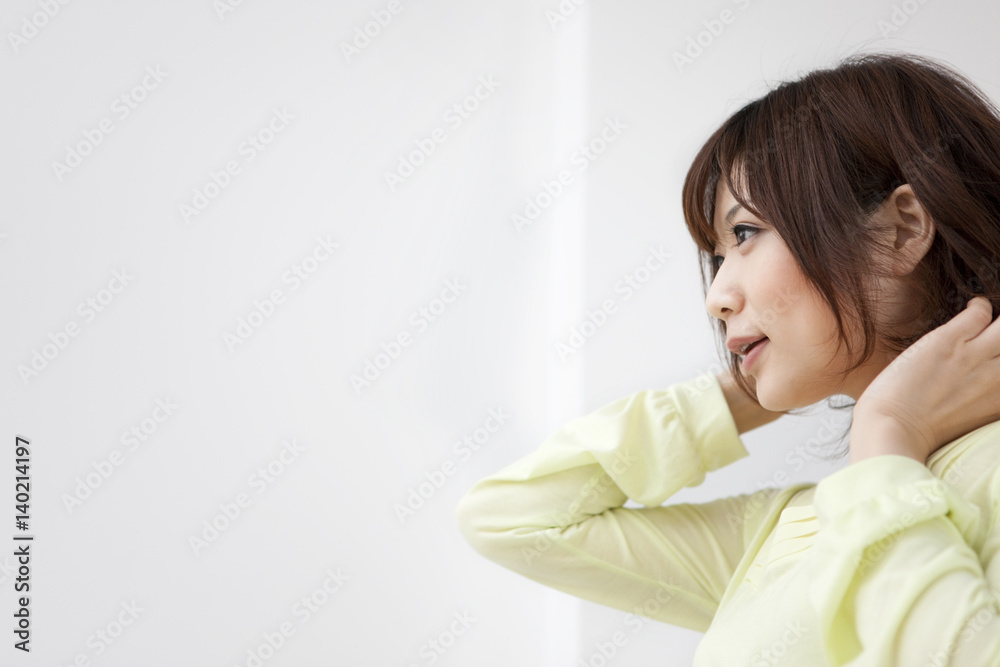 Young woman touching hair, white background, copy space Young woman touching hair, white background, copy space