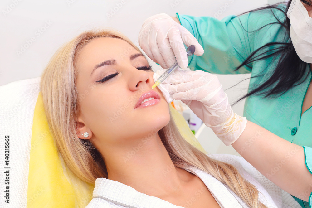 Fototapeta premium Injection in her lips and face.