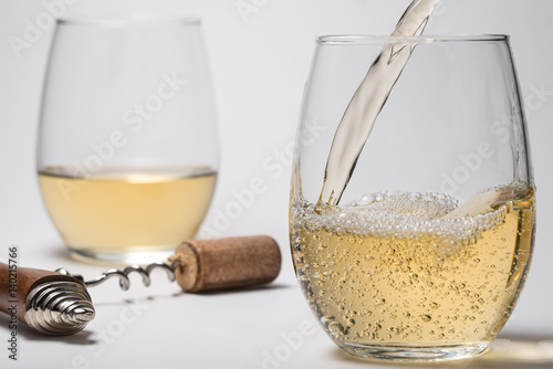 Pouring White Wine into Stemless Glasses photo