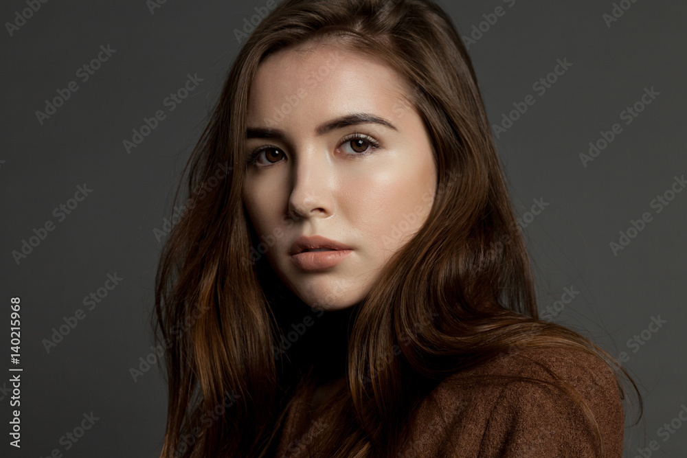 Cute young model brunette woman with clear skin on gray background Cute young model brunette woman with clear skin on gray background