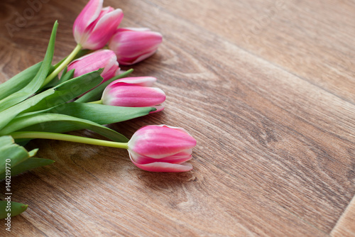 Spring pink tulips on a brown wooden background