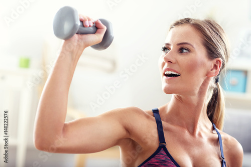 Woman exercising with dumbbells at home