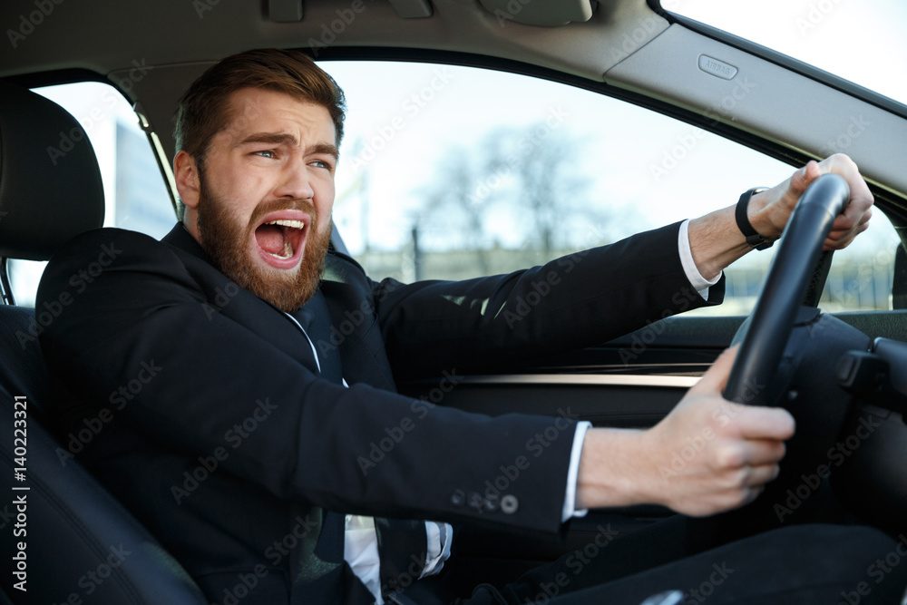Screaming young business man getting into car accident while driving Screaming young business man getting into car accident while driving
