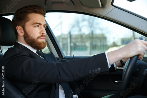 Handsome young business man driving his car © Drobot Dean