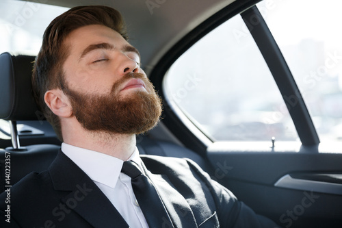 Business man sleeping in the back seat of a car © Drobot Dean