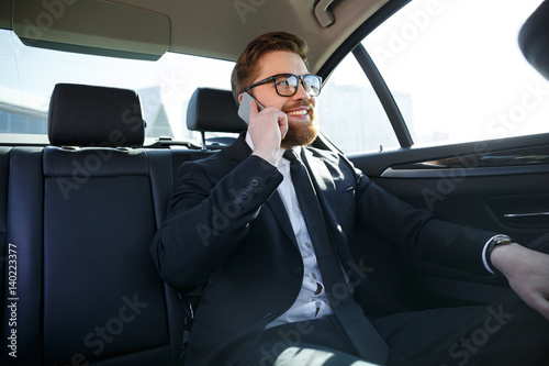 Smiling bearded business man in eyeglasses talking on cell phone © Drobot Dean