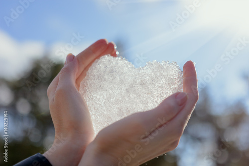 Human hands heart against snow background, St.Valentine's Day romantic concept.