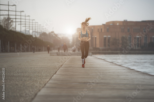 a woman jogging by the seaside in urban city environment © PhotoPlus+