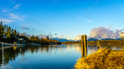 Sunset over the Fraser River with old wooden pilings used to tie log booms at Brae Island near the historic town of Fort Langley, British Columbia