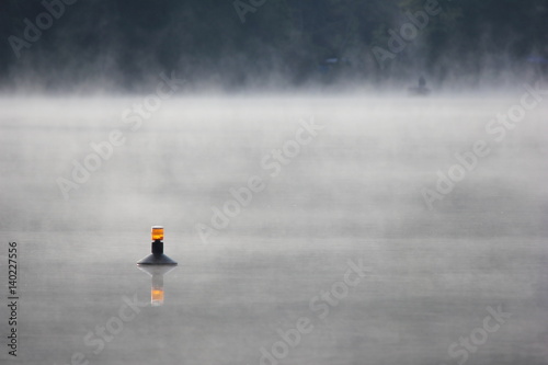 misty lake with buoy
