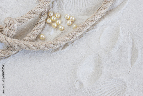 holidays concept/ pearls and rope on a white sand