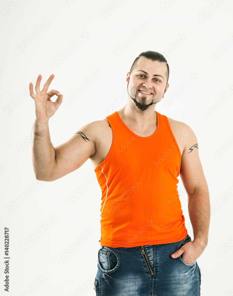 portrait of sporty guy - bodybuilder in jeans and an orange shir portrait of sporty guy - bodybuilder in jeans and an orange shir