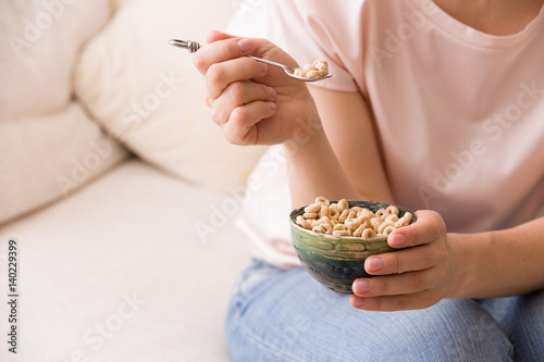 Closeup of woman's hands holding bowl with organic whole wheat cereal. Healthy Breakfast or snack. Healthy food and eating. photo