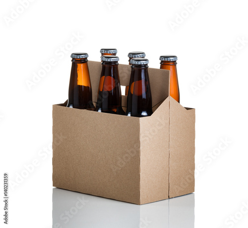 Six pack of glass bottled beer in generic brown cardboard carrier on white background