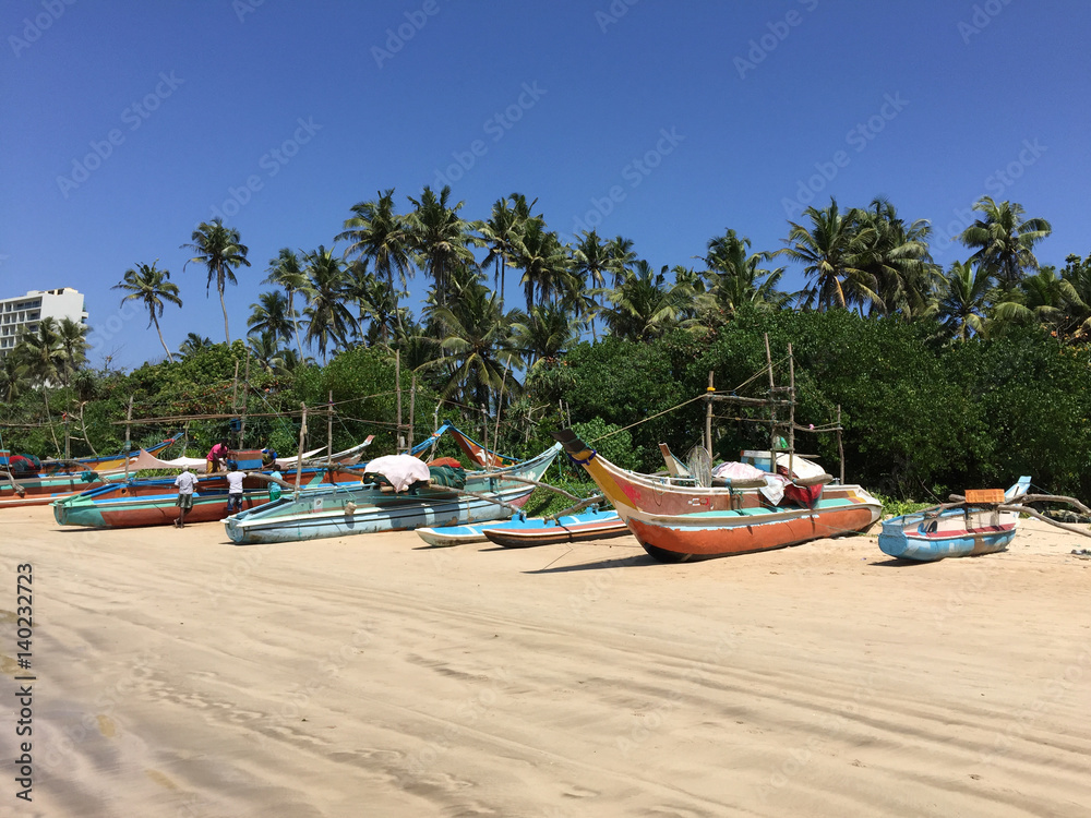 Local fishing boats lined along the beach at Weligama bay, Sri Lanka