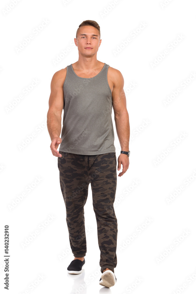 Young Man In Camo Sweat Pants Walking Towards Camera