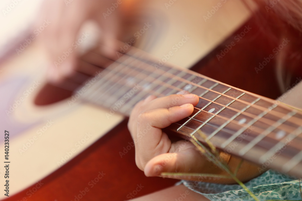 Fototapeta premium Girl playing guitar, closeup