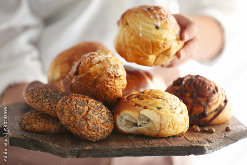 Woman holding fresh bakery products, closeup