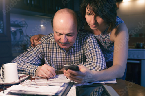 daughter helps her father count money and manage the family budget