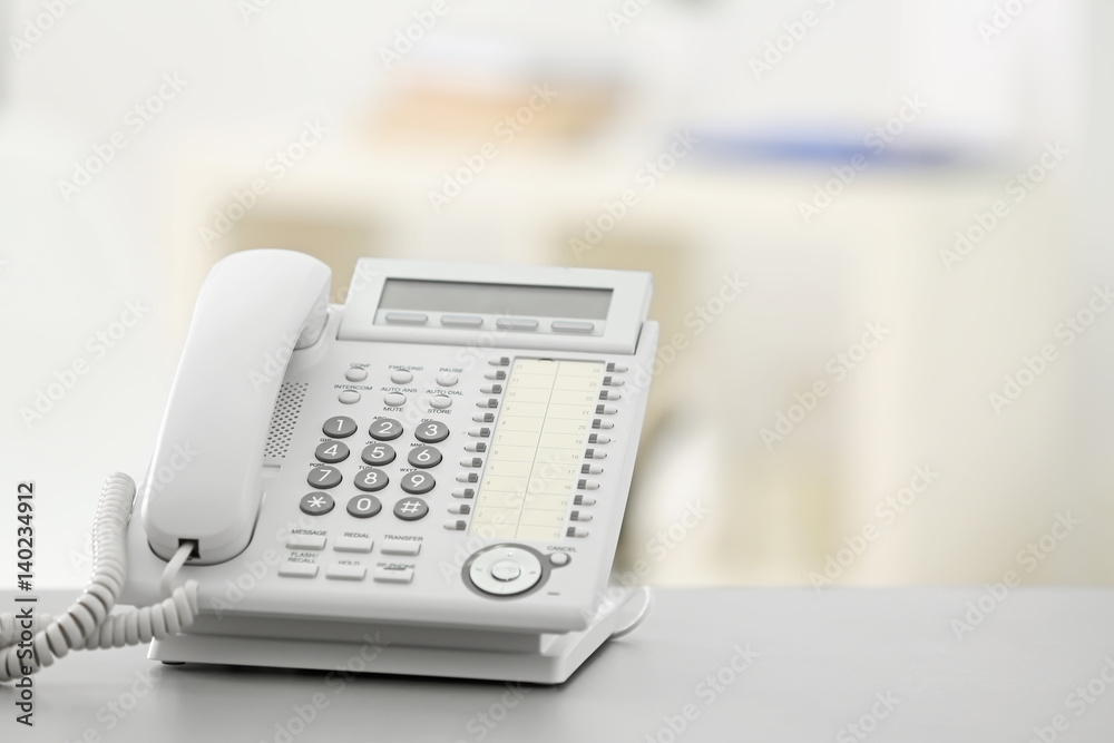 Telephone on table against blurred background Telephone on table against blurred background