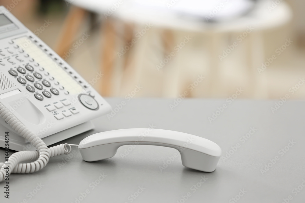 Telephone with picked up receiver on table in office Telephone with picked up receiver on table in office