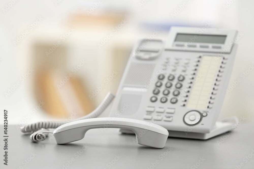 Telephone with picked up receiver on table in office Telephone with picked up receiver on table in office