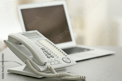 Telephone on table at workplace of technical support agent