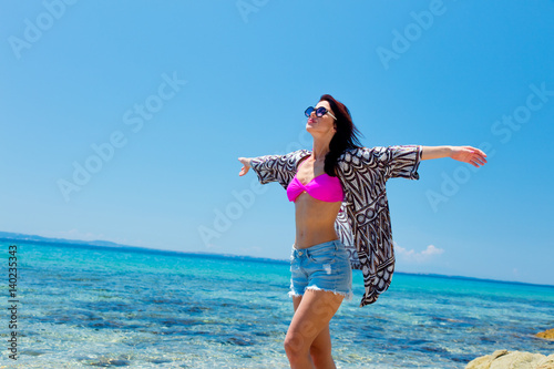photo of beautiful young woman standing on the coast and relaxing in Greece