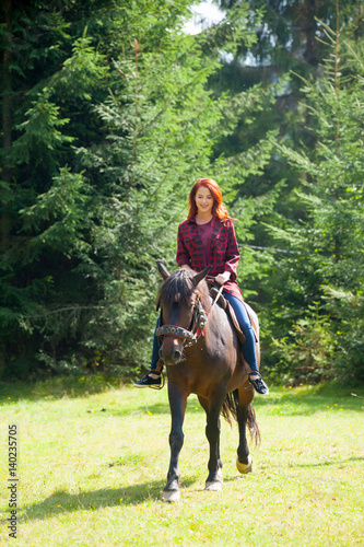 beautiful young woman on the wonderful horse on the natural forest background