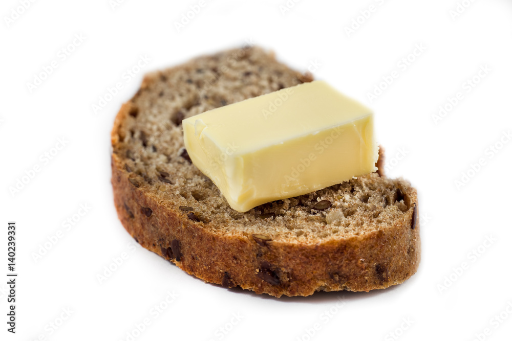 Dark rye bread with seeds and butter on white background