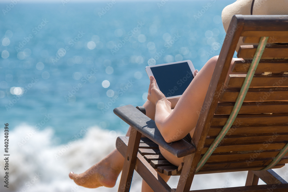 Blank empty tablet computer in the hands of women on the beach