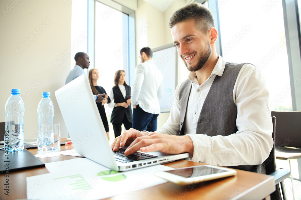 Handsome businessman working with laptop in office. Handsome businessman working with laptop in office.