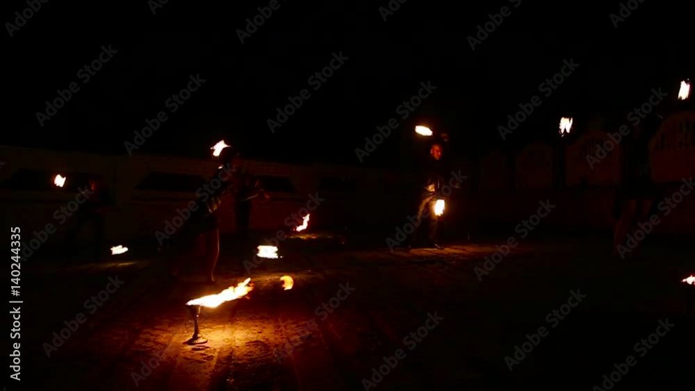 Graceful girls dancing passionate dance with fire fan in his hand. Fire show Graceful girls dancing passionate dance with fire fan in his hand. Fire show