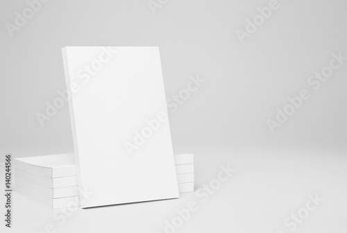 Real paperback white book over a stack of books on a gray background