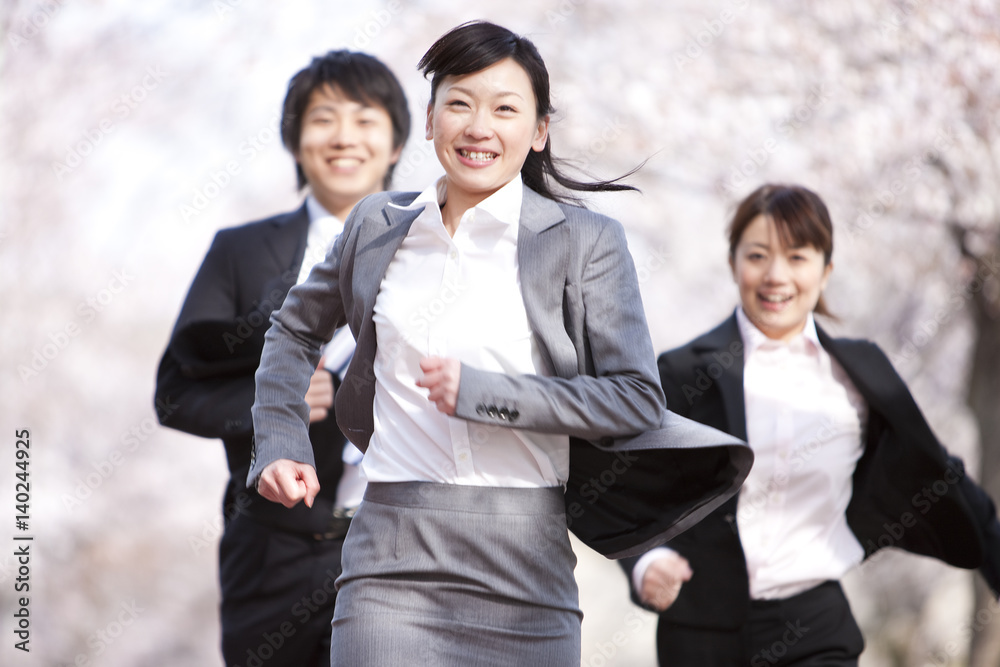 Business people running under cherry blossoms Business people running under cherry blossoms