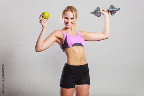 Diet fit body. Girl holds dumbbells and apple fruit © Voyagerix