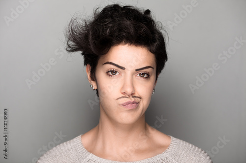 Woman with Drawn Mustaches on Gray Background Making Face